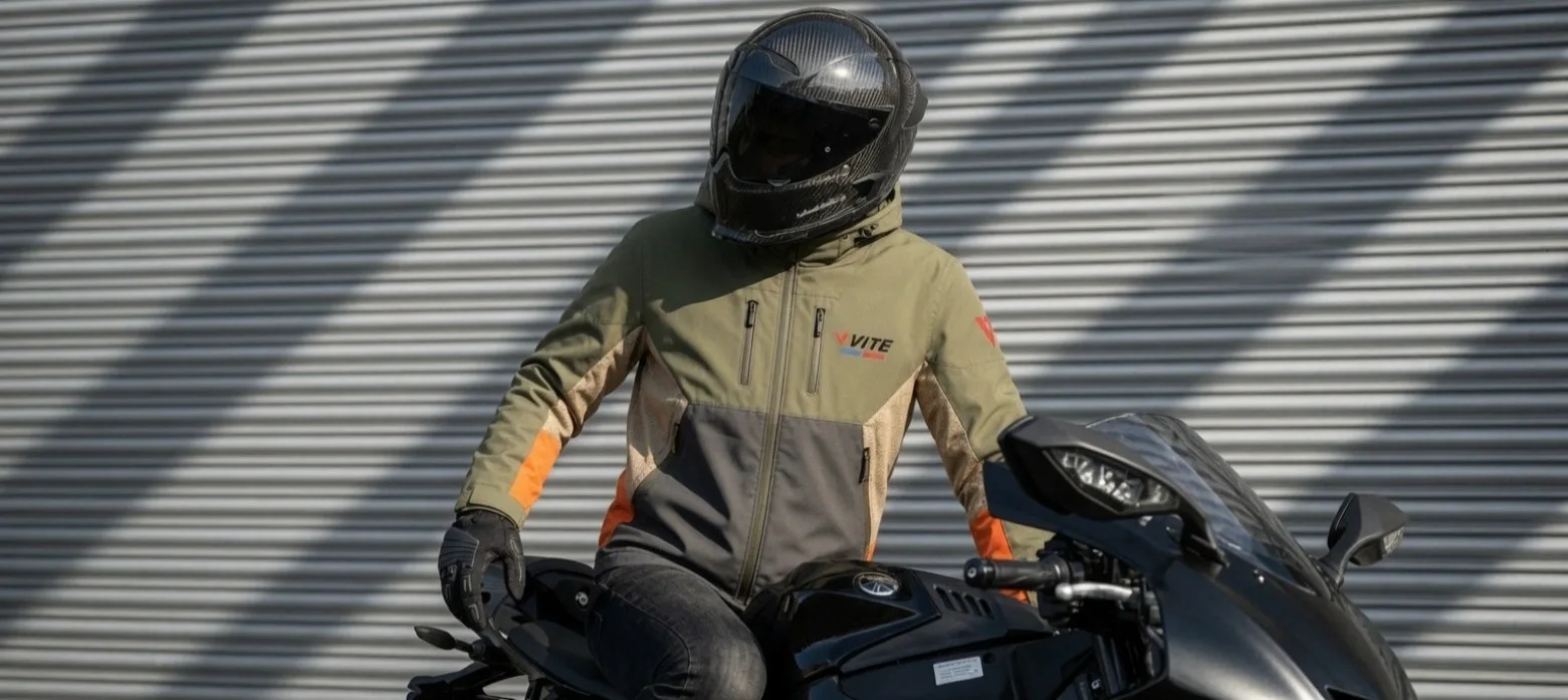 Rider in VITE jacket beside a motorcycle